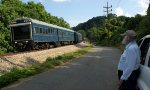 Regular train watcher at Reusens watches the W001 geometry train sail around the curve near the west end of the siding